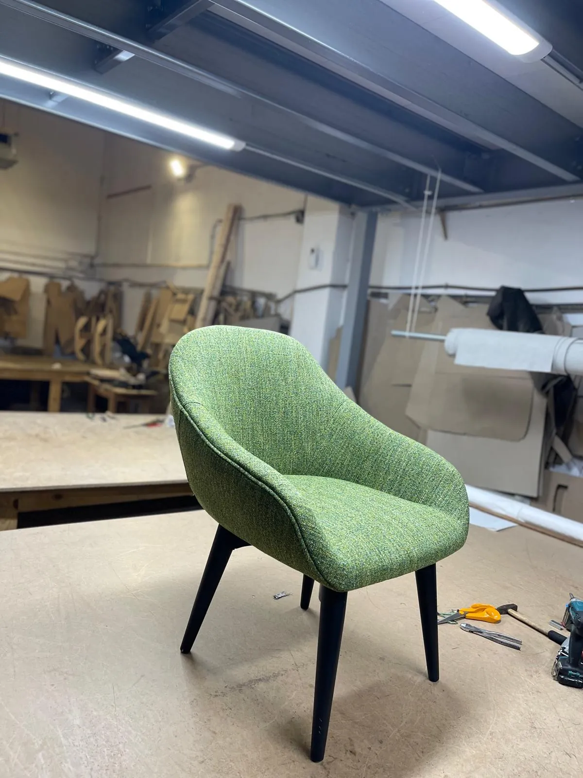 Silla tapizada en tela verde con patas negras