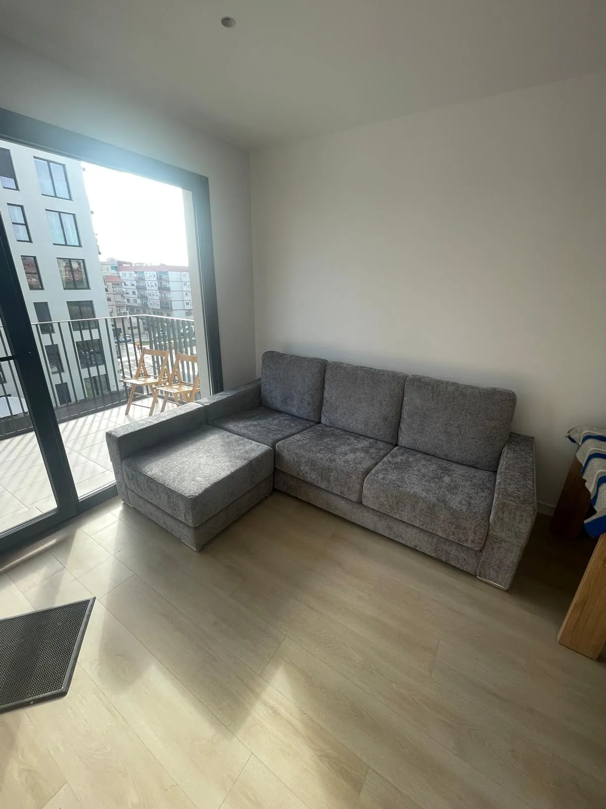 Chaise longue gris junto a la ventana